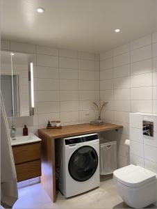 a bathroom with a washing machine and a toilet at Luxurious villa with free parking in Gothenburg
