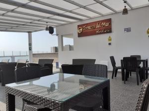 a dining room with a glass table and chairs at Hotel Terrazas Del Mar in Huacho