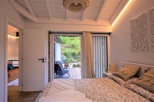 a bedroom with a bed and a door to a balcony at COUNTRY HOUSE by the RIVER - NATIONAL PARK in Arcos de Valdevez