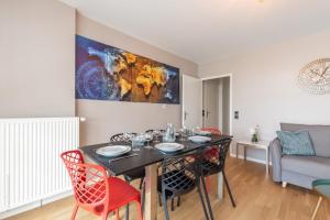 a dining room with a black table and red chairs at La Dolce Vita By Plaza in Chessy