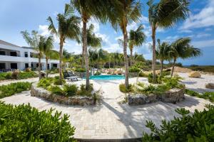 um resort com piscina e palmeiras em The Reef - Blue Bay Golf & Beach Resort em Willemstad