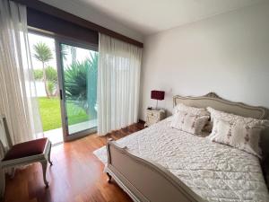 sypialnia z łóżkiem i dużym oknem w obiekcie Vila Chã Beach House by Trip2Portugal w mieście Vila Chã