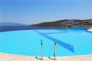 a large swimming pool with a view of the ocean at Castamar Residence in Bodrum City