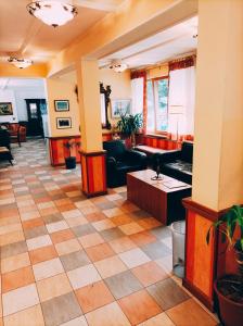 a lobby with couches and tables in a building at IHR Hotel Villa Emma in Canazei