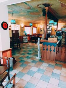 a restaurant with a checkered tile floor and a counter at IHR Hotel Villa Emma in Canazei
