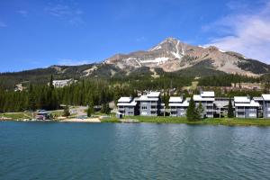 un complexe sur la rive d'un lac avec une montagne dans l'établissement Prismatic Mountain Studio Less Than 1 Mi to Big Sky Resort, à Big Sky