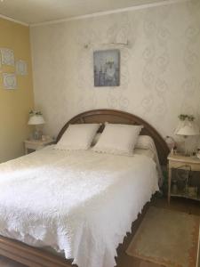 sypialnia z dużym białym łóżkiem z dwoma stołami w obiekcie Le Havre de paix w mieście Saint-Cyr-sur-Loire