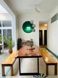 a living room with a wooden table and benches at AnandMai - Sustainable Living Spaces in Jaipur