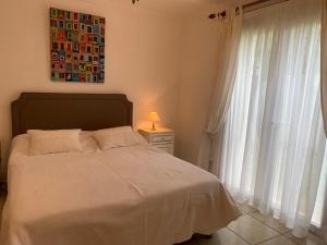 una camera da letto con un letto bianco e una finestra di Villa proche cap d’agde a Bessan Altre 20 foto