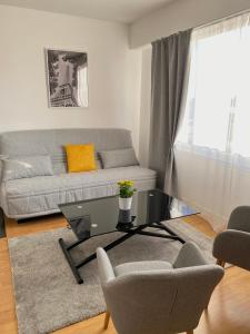 a living room with a couch and a table at Panoramic View Studio - 15 min from Paris in Joinville-le-Pont