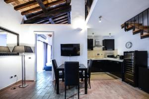 a kitchen and dining room with a table and chairs at Ibernesi - Charming apartment at the Roman Forums in Rome