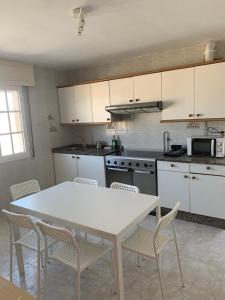 a kitchen with a white table and chairs at Apartamento en Rias Baixas-Aguiño-Ribeira in Ribeira
