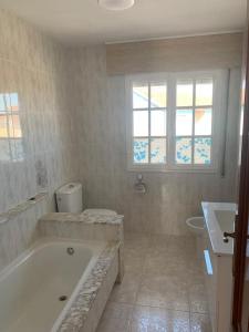 a white bathroom with a tub and a sink at Apartamento en Rias Baixas-Aguiño-Ribeira in Ribeira