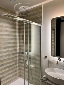 uma casa de banho com um chuveiro e um lavatório. em G&W Luxury Rooms em Atenas