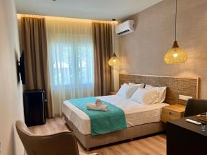 ein Hotelzimmer mit einem Bett mit einem Handtuch darauf in der Unterkunft G&W Luxury Rooms in Athen