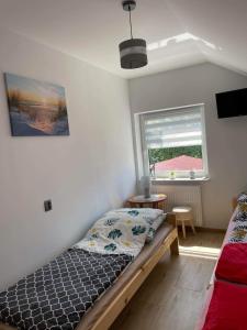 a bedroom with a bed and a window at Dom wypoczynkowy FENIX in Werblinia