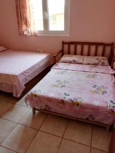 sypialnia z 2 łóżkami i oknem w obiekcie Αξέχαστη διαμονή - Unforgettable accommodation w miejscowości Nea Kallikratia
