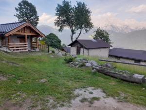 a cabin in a field with mountains in the background at Baita Martin da Fist in Caderzone Terme +72 photos