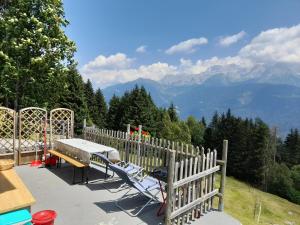 a picnic table and bench on top of a mountain at Baita Martin da Fist in Caderzone Terme