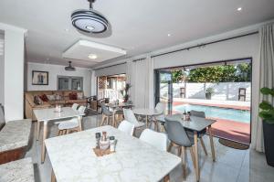 una sala de estar con mesas y sillas y una piscina en Casa Milner Guest House, en Ciudad del Cabo