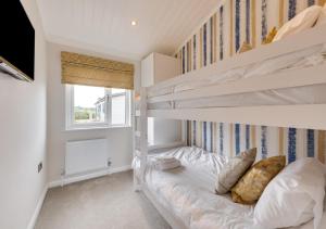 a bedroom with two bunk beds and a window at Briargate 38 in Burnham Market