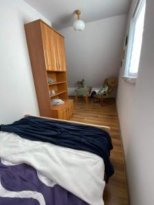 1 dormitorio con 1 cama y armario de madera en Willa Paulina, en Nadole