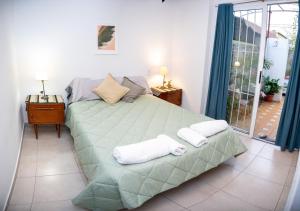 Bienvenido a Café y Vino في غوايمالين: غرفة نوم بسرير كبير عليها مناشف