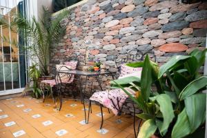 Bienvenido a Café y Vino في غوايمالين: فناء مع طاولة وكراسي وجدار حجري