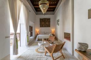 1 dormitorio con 1 cama, mesa y sillas en Riad Safar, en Marrakech