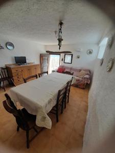a dining room with a table and a living room at Baita Martin da Fist in Caderzone Terme