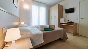 a bedroom with a bed and a table with a lamp at Wally Residence in Rimini