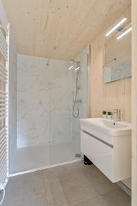 baño blanco con ducha y lavamanos en Chalet Babette, en Koksijde