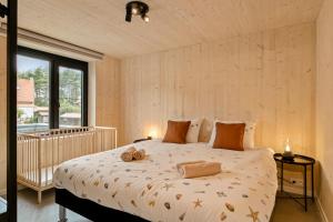 a bedroom with a bed with two towels on it at Chalet Babette in Koksijde