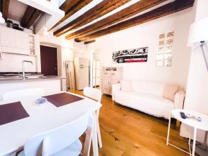 een witte keuken en een woonkamer met een witte bank bij [ARCO DELLA PACE - SEMPIONE] - Moderno Bilocale in Milaan