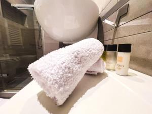 een witte handdoek op een badkamerbar met een aantal producten bij [ARCO DELLA PACE - SEMPIONE] - Moderno Bilocale in Milaan