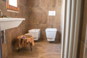 a bathroom with a toilet and a sink and a table at Tre Cercole - Eco Resort in San Marco in Lamis +30 photos