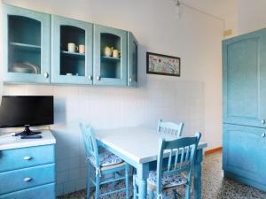 een keuken met blauwe kasten en een witte tafel en stoelen bij Maurizia's house in Levanto