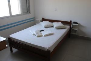 un letto in una camera con due cuscini sopra di Satélite - Itanhaém a Itanhaém