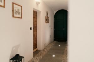 a hallway with a green door and a table at Residence Antico Torchio in Dervio