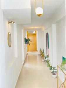 a hallway with potted plants and a yellow door at AnandMai - Sustainable Living Spaces in Jaipur