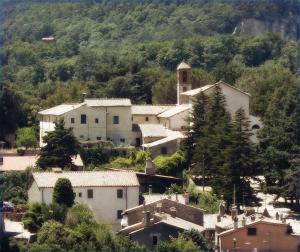 uma pequena aldeia numa colina com uma igreja em Convento dei Cappuccini em Tolfa