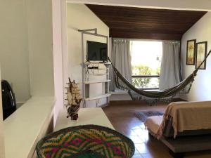 a bedroom with a hammock in a room with a window at Natureza e mar no Bracuhy in Angra dos Reis
