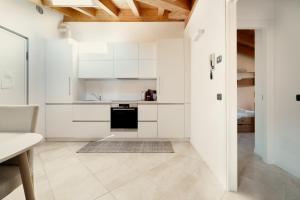 a kitchen with white cabinets and a stove top oven at Residence Antico Torchio in Dervio