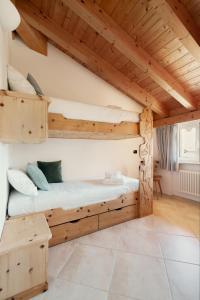 a room with two bunk beds and a wooden ceiling at Residence Antico Torchio in Dervio
