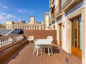 バルセロナにあるnuma I Boqueria Apartmentsの木製デッキ(テーブル、椅子付)