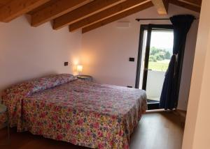 Schlafzimmer mit einem Bett und einer Glasschiebetür in der Unterkunft Al Settimo Miglio, alloggio agrituristico in Treppo Grande