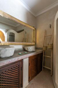 a bathroom with a vanity with a large mirror at Riad Safar in Marrakesh