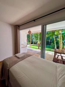 a bedroom with a bed and a large window at Tucano Pousada in Cumbuco