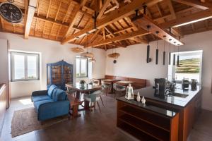 una gran sala de estar con un sofá azul y mesas. en Casa dos Romeiros, en Santa Bárbara