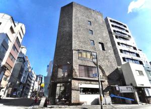 ein hohes Gebäude in einer Stadtstraße mit Gebäuden in der Unterkunft Senlax Inn Osaka in Osaka